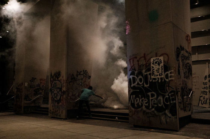 Protesters run as tear gas is deployed on the steps of the U.S. District Court building on July 17, 2020 in Portland, Oregon. Federal law enforcement agencies attempt to intervene as protests continue in Portland.