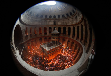 Christian Orthodox worshipers hold up candles lit from the Holy Fire as they gather in the Church of the Holy Sepulchre in Jerusalem's Old City on April 27, 2019, during the Orthodox Easter. - The ceremony celebrated in the same way for eleven centuries, is marked by the appearance of 'sacred fire' in the two cavities on either side of the Holy Sepulchre.